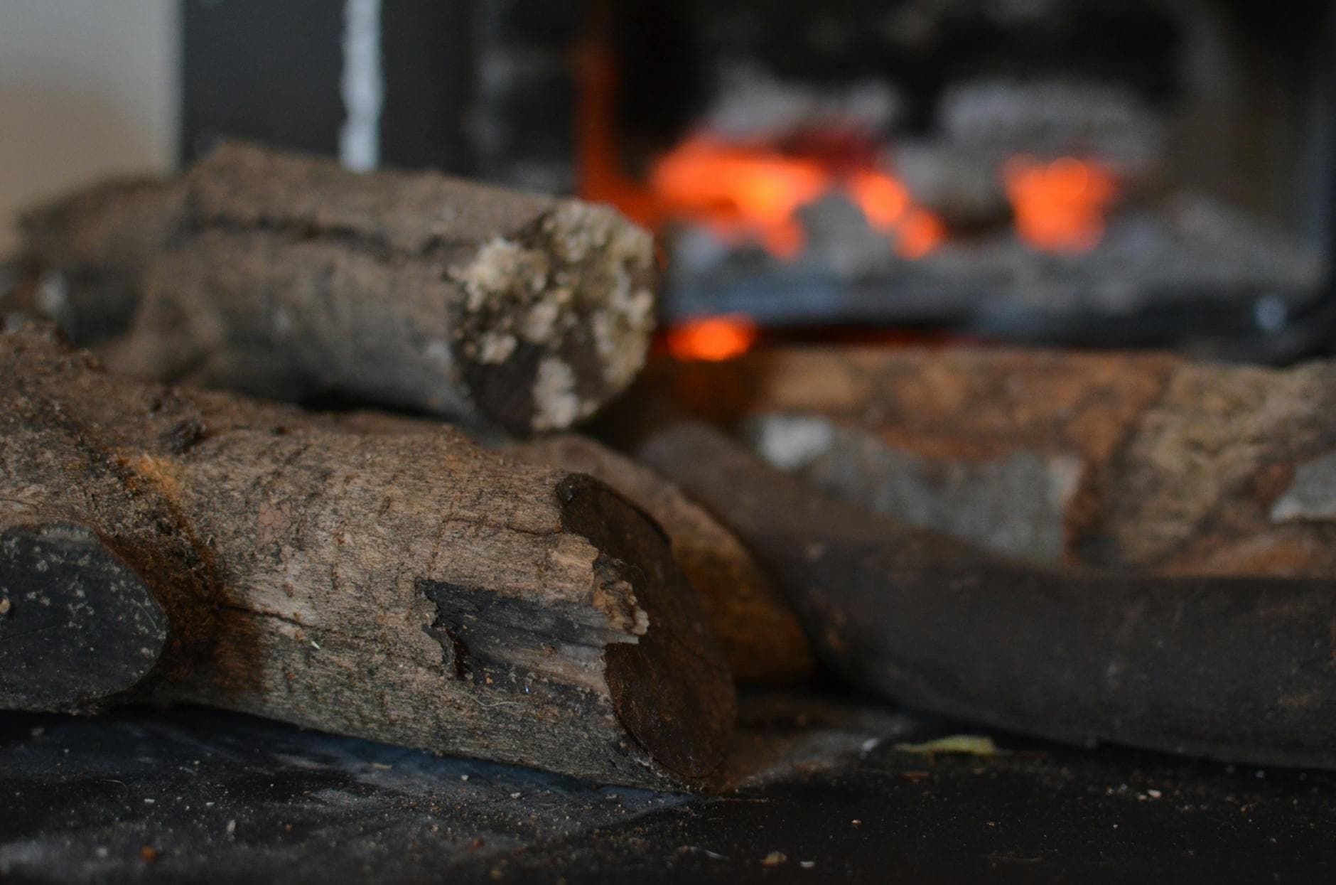 Detailed close-up of wood logs in front of a blurred fire background, creating a warm ambiance.